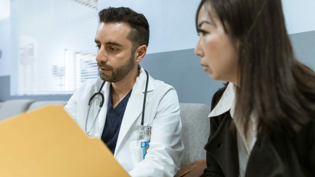 Un médico habla con una paciente en la consulta sobre su prueba de clamidia