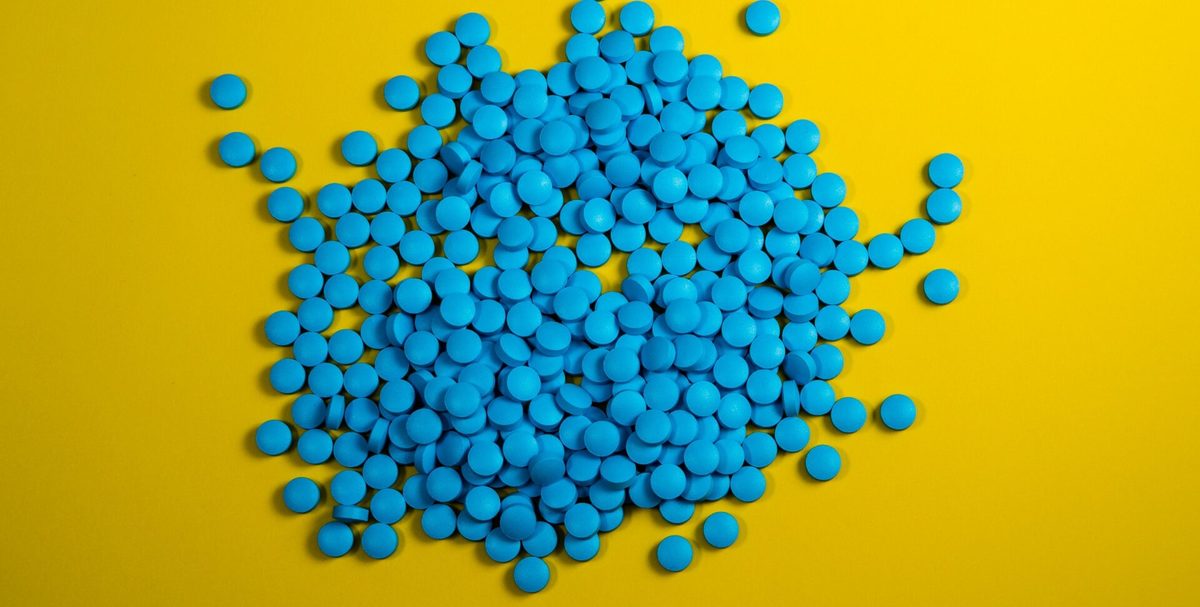 Pastillas azules amontonadas sobre un fondo amarillo