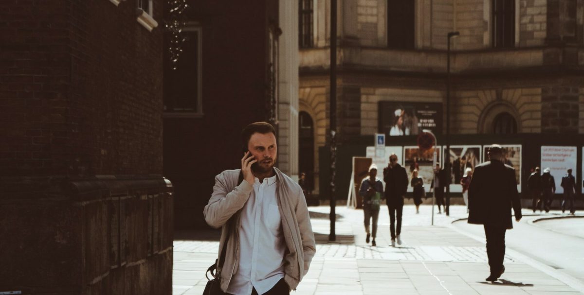 Un hombre habla por teléfono mientras camina por una calle de la ciudad